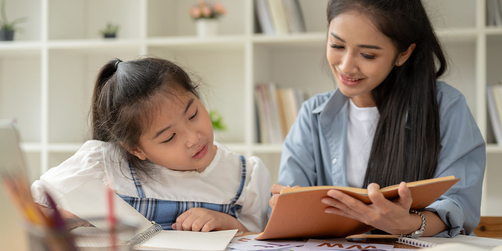 A child reading aloud with a reading trainer at The Brain Workshop in Dubai